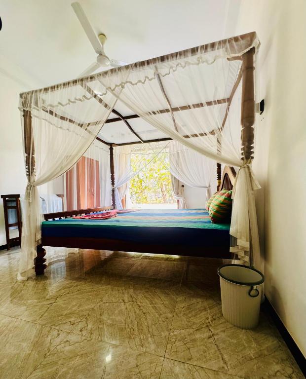 un letto in una camera con zanzariera di Villa Sureka a Hikkaduwa