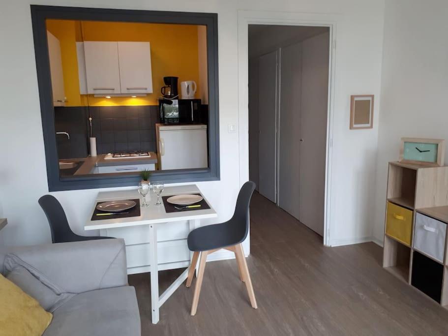 a room with a table and a chair and a kitchen at Joli studio au centre ville in Aix-les-Bains