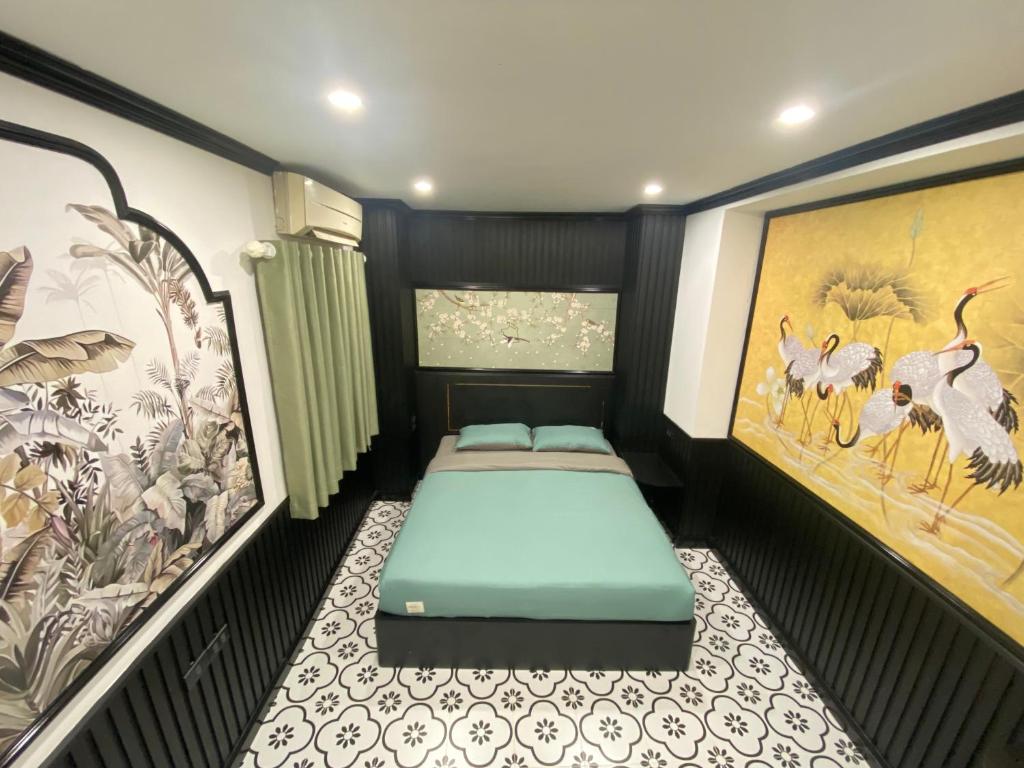 Habitación pequeña con cama y mural en Laca Homestay HangDa, en Hanói