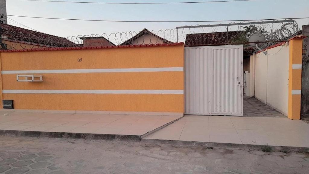 un bâtiment orange et blanc avec une porte blanche dans l'établissement Casa de férias luar do prado, à Prado