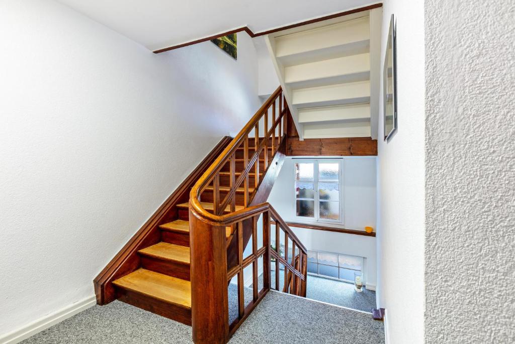 a wooden staircase in a house with white walls at Haus Am Bühl in Schönau im Schwarzwald