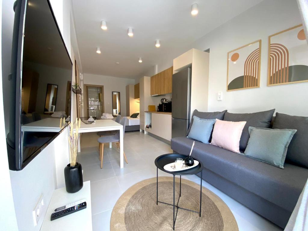 a living room with a blue couch and a table at Alki-House in Athens