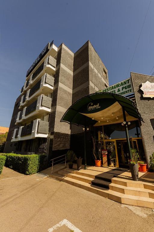 a building with an umbrella in front of it at Hotel Sport B90 in Buzău