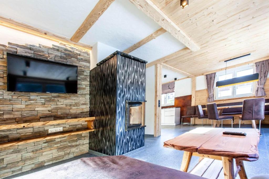 a living room with a stone wall with a fireplace at Casa de Wisa in Gaschurn