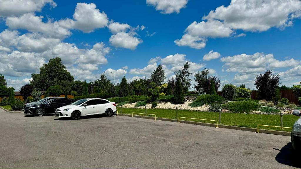 un coche blanco aparcado en un estacionamiento en Ні пуху, ні пера!, en Reshetylivka