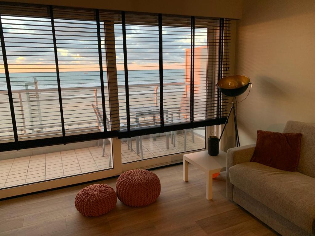 a living room with a couch and a large window at Appartement Admare Middelkerke in Middelkerke