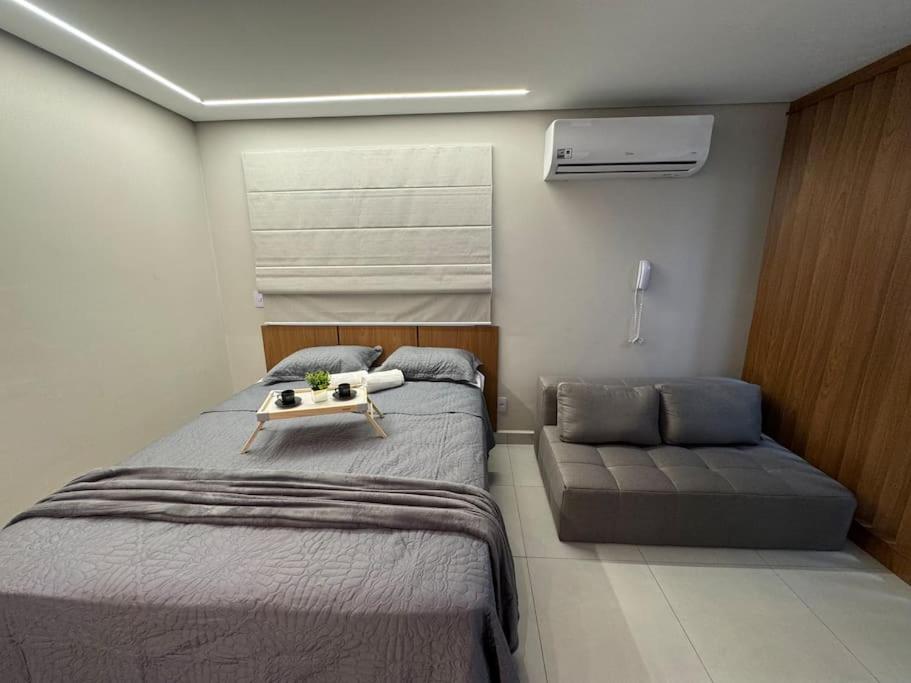a small bedroom with a bed and a couch at Apartamento 121 - Home in Ribeirão Preto