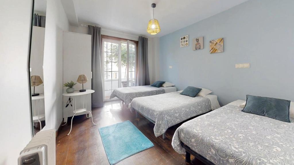 a bedroom with two beds and a window at Vivenda Center Porto in Porto