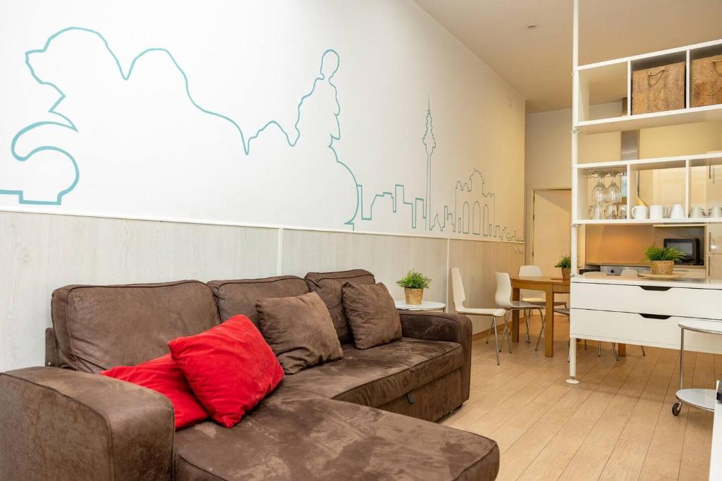 a living room with a brown couch with a red pillow at Modern and spacious-2Bedrooms 1Bathroom-Malasaña in Madrid