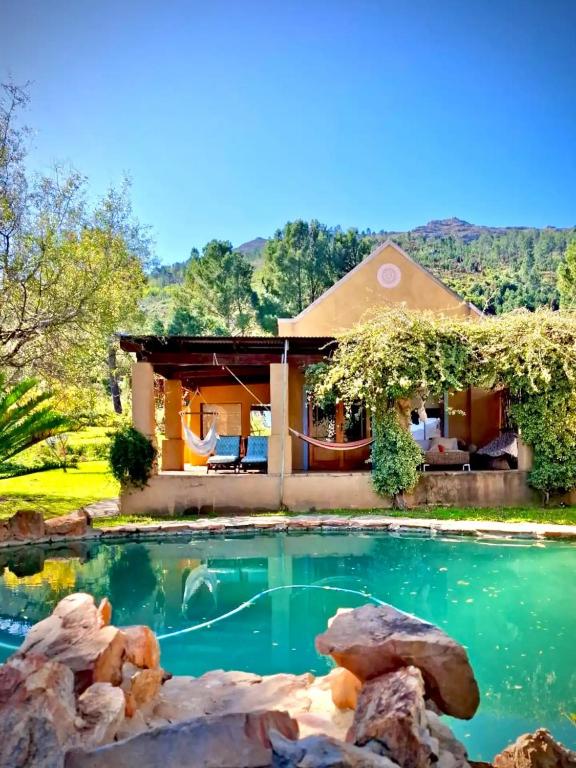 a house with a swimming pool in front of a house at Simunye Cottage in Simondium