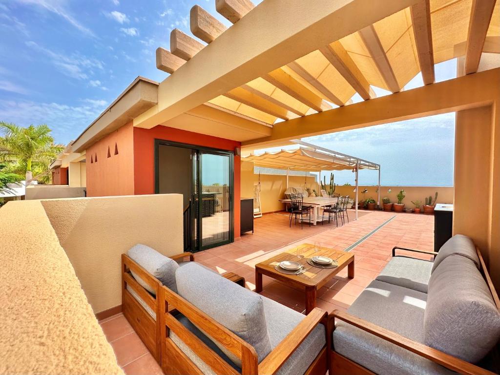 an outdoor patio with a couch and a table at Paradise Ocean and Volcano View in Playa Paraiso