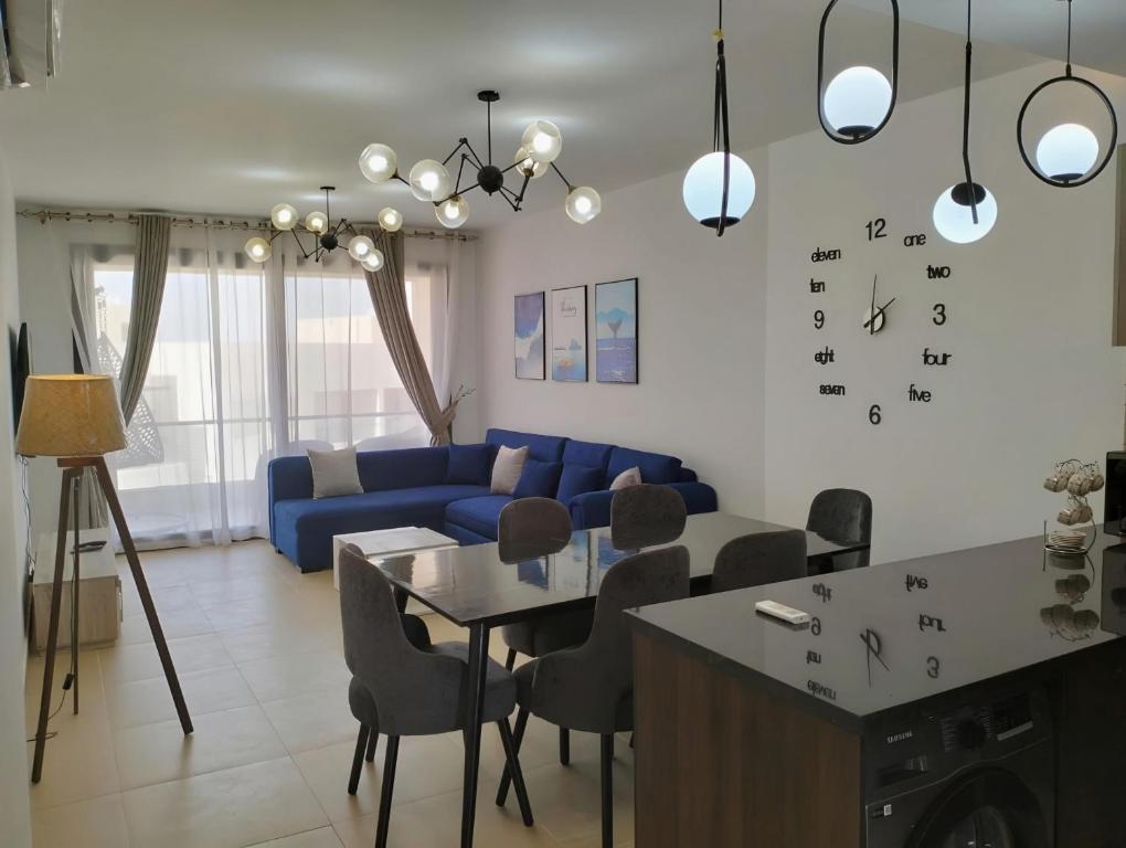 a living room with a blue couch and a table at Relax at Celia Luxury 2 bedroom chalet at Azha in Ain Sokhna