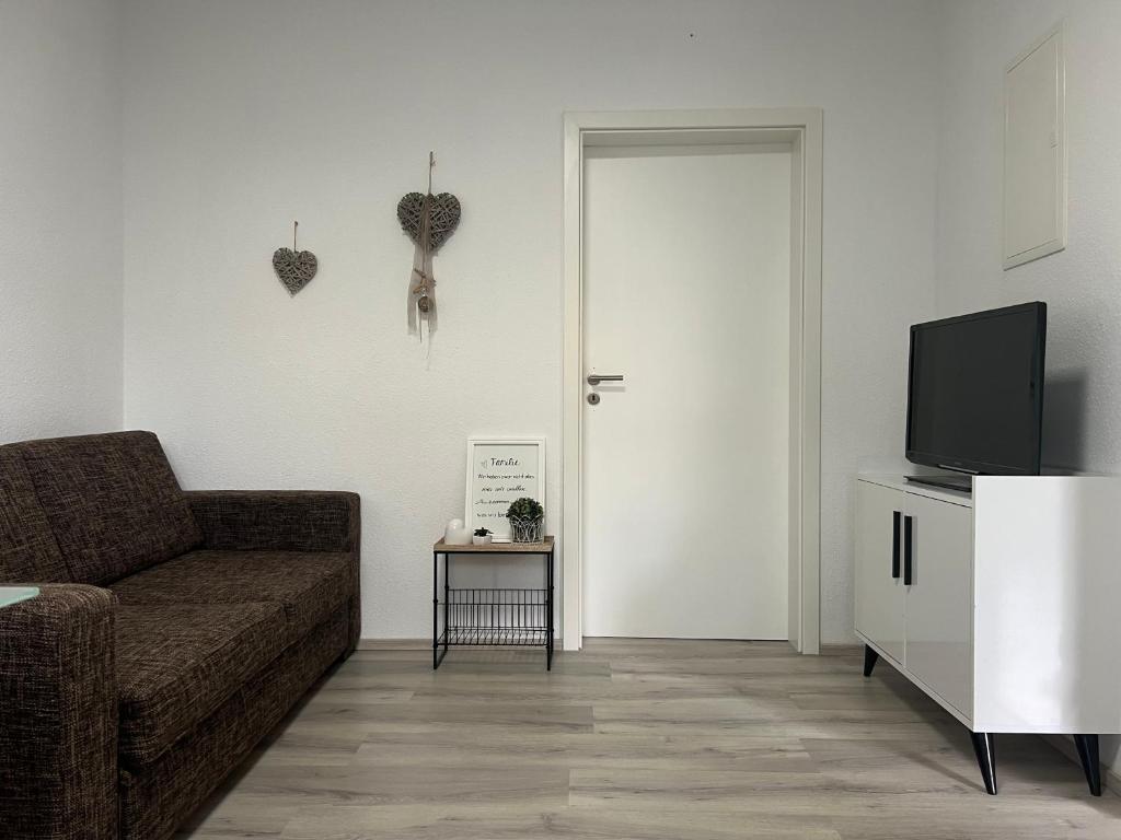 a living room with a couch and a tv at Waldnest ,Moderne Ferien und Monteurwohnung in Ardey
