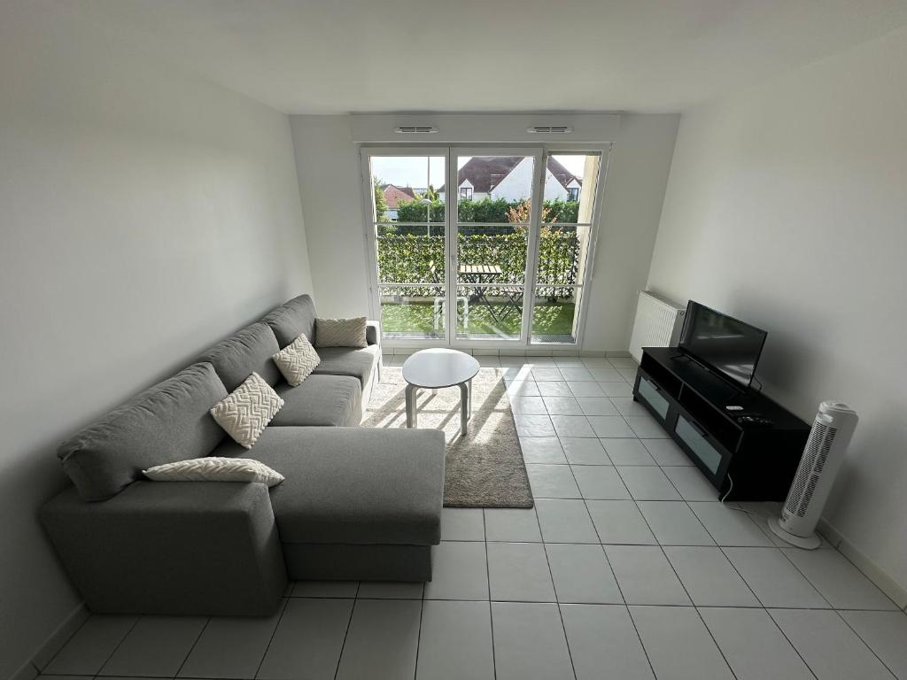 a living room with a couch and a tv at Aéroport CDG, Paris Disneyland, Eiffel Tower, JO 2024 in Montévrain