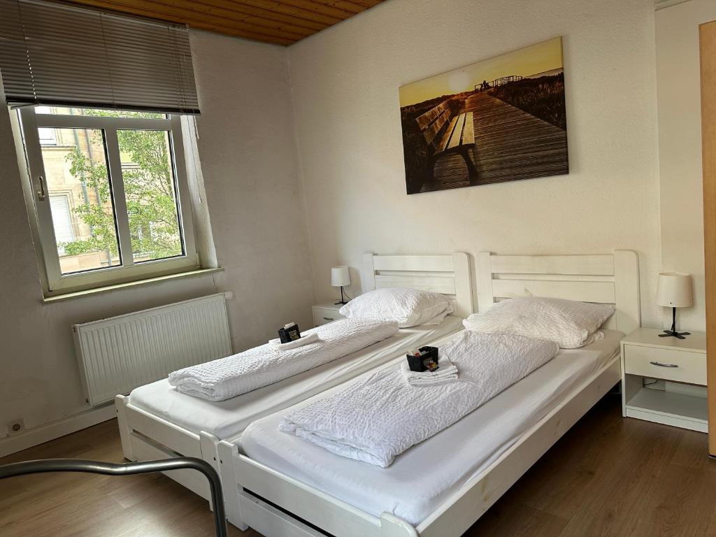 2 camas blancas en una habitación con 2 ventanas en Privatzimmer Fürth Zentrum, en Fürth