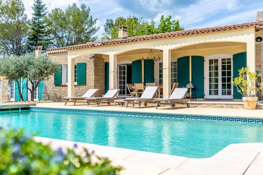 une maison avec une piscine bordée de chaises longues dans l'établissement Villa Les Restanques - Piscine et Pétanque, à Rougiers