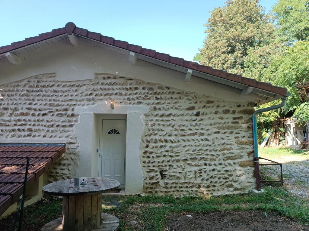 - un bâtiment en pierre avec une porte blanche et une table dans l'établissement Appart complet 2 chambres calme facture et repas possibles, à Beausemblant
