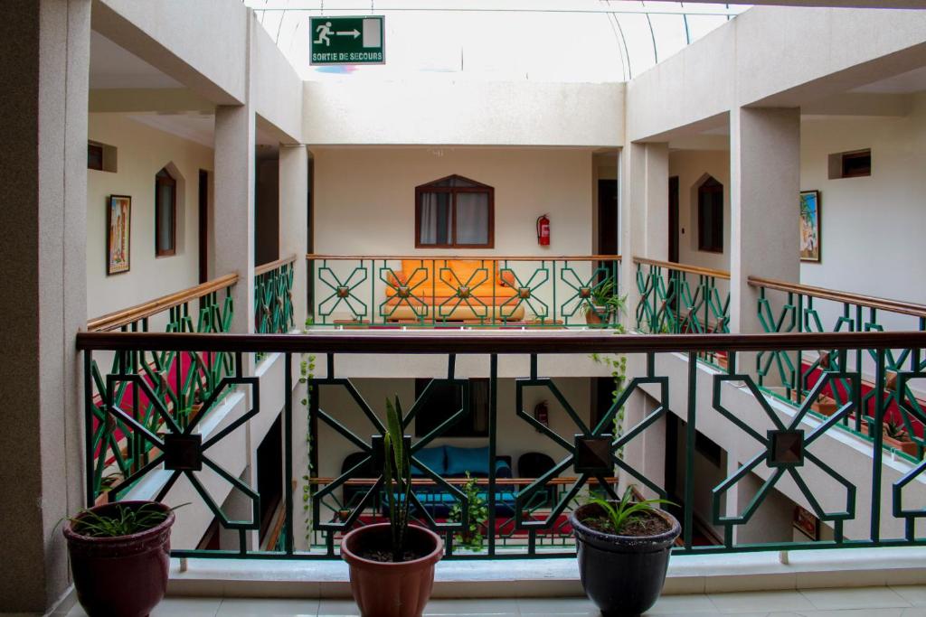 arium eines Gebäudes mit Topfpflanzen auf einem Balkon in der Unterkunft Hôtel Riad Asfi in Safi