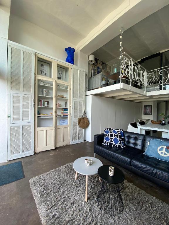 un salon avec un canapé noir et une table dans l'établissement Nirvana Loft, à Théoule-sur-Mer