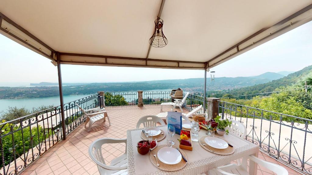 een tafel en stoelen op een balkon met uitzicht bij Casale Massina APPARTAMENTO GIADA in Salò