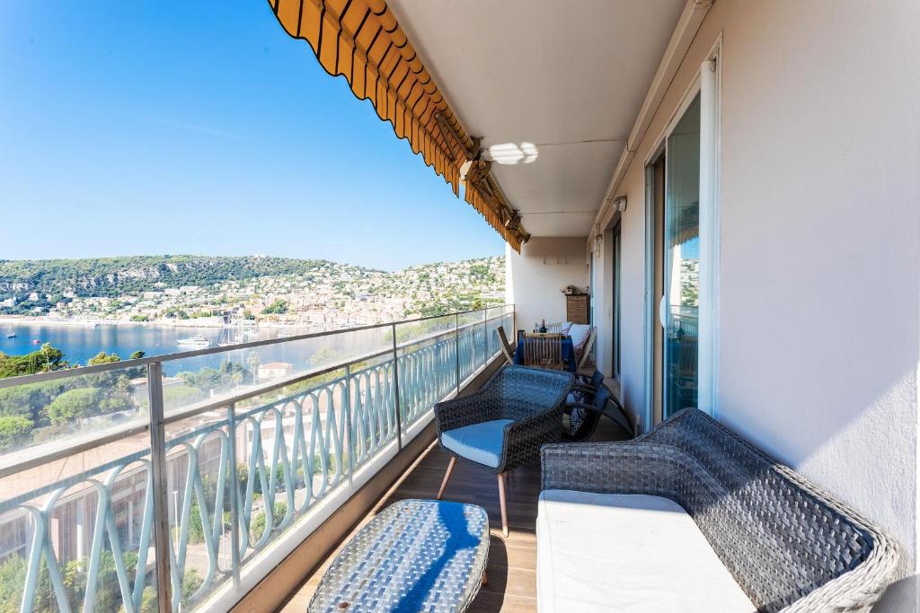 d'un balcon avec des chaises et une vue sur l'eau. dans l'établissement LE MIRAMAR AP4426 By Riviera Holiday Homes, à Villefranche-sur-Mer