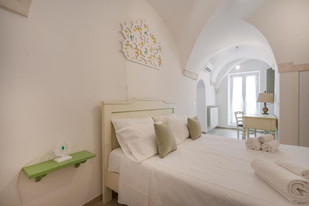 een slaapkamer met een groot wit bed met handdoeken erop bij Giona's guest house by IL PUMO DI PUGLIA in Martina Franca