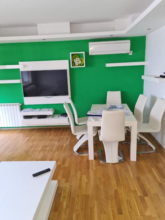 a office with a green wall and a table and chairs at Villa Kale Luxury in Skopje