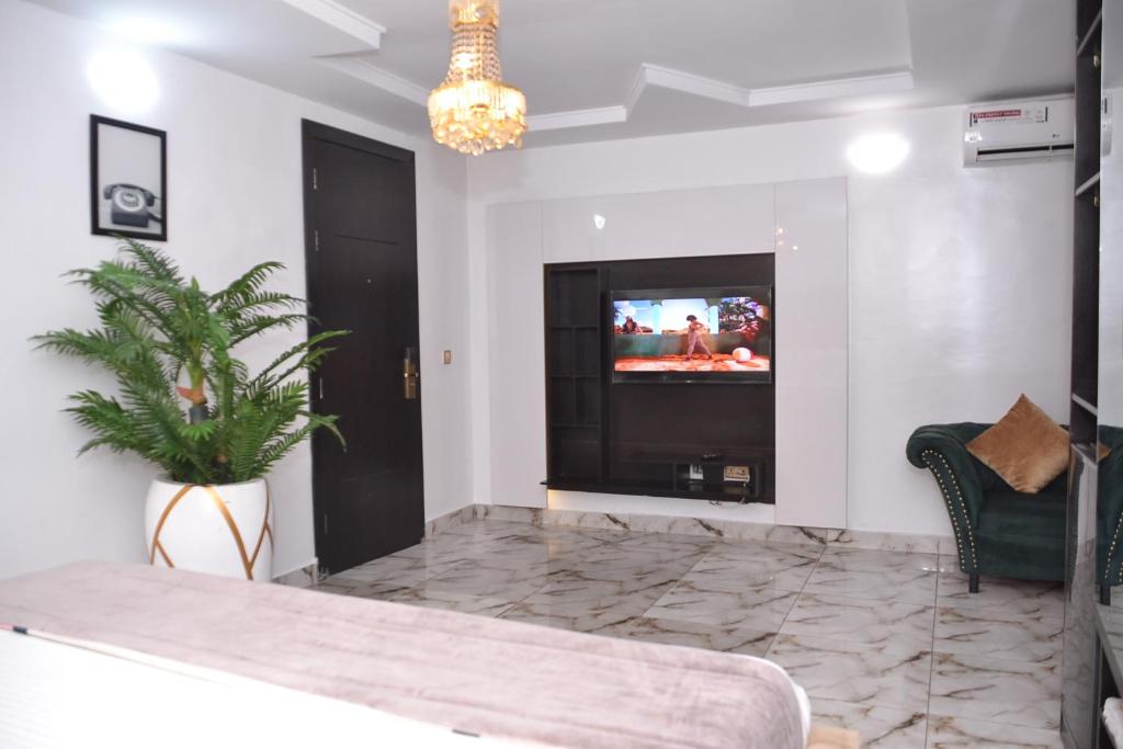 a living room with a tv and a potted plant at Luxury Hotel Deluxe Room - Sleeps 2 - Gym - Pool in Lekki