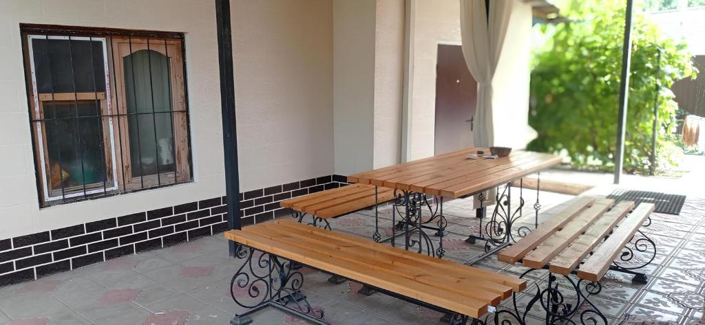 two wooden tables and benches next to a building at VIP 2 Квартира-студия 1ком in Uralsk