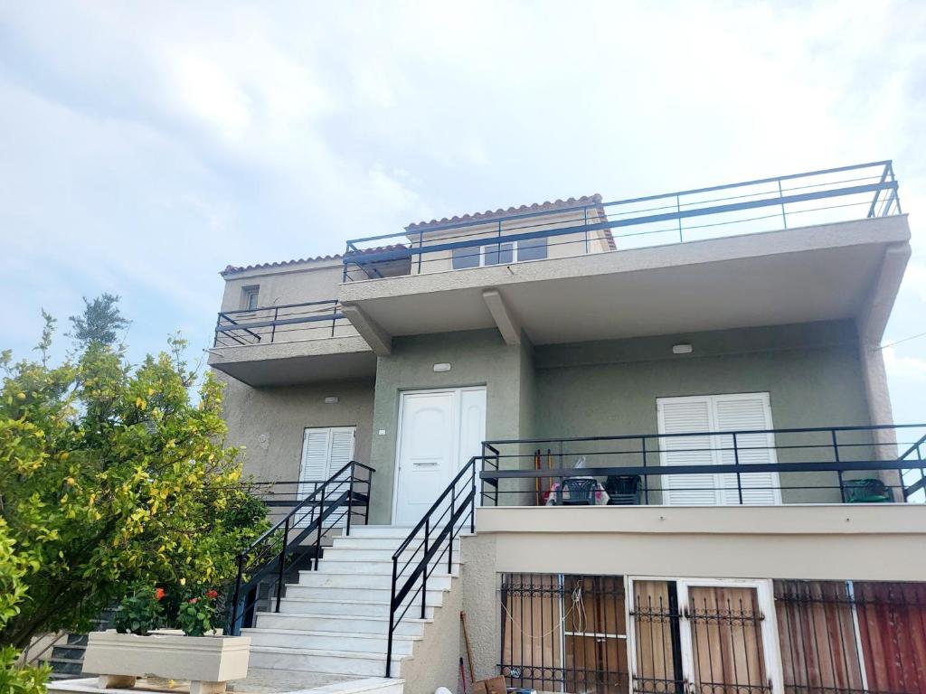 MalakóndasにあるMarys Home Eretriaのバルコニーへ続く階段のある建物