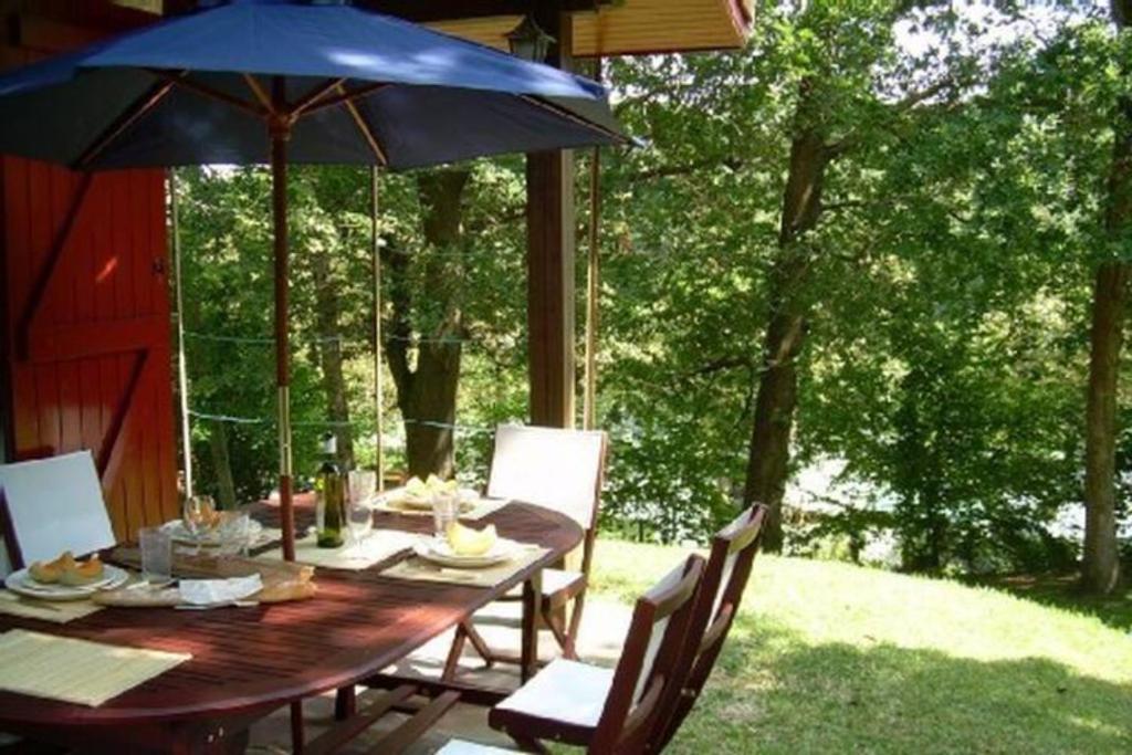 a wooden table with an umbrella on a patio at Maison vacances Biarritz sud - plages à pied in Bidart