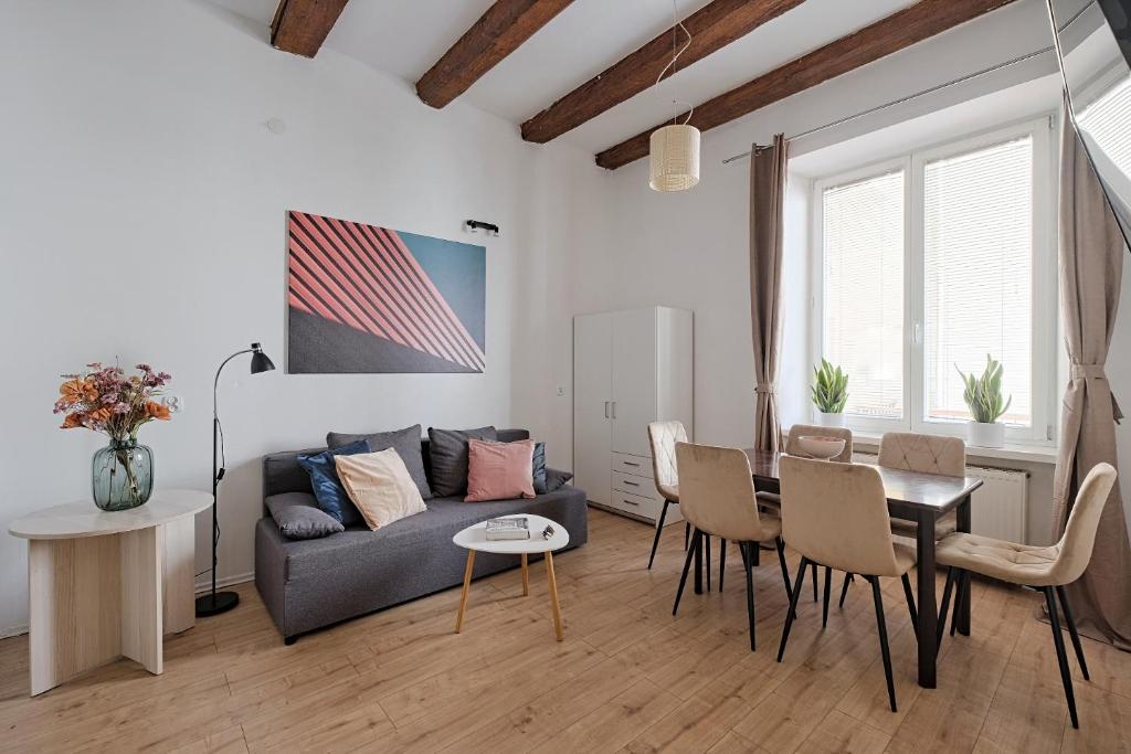 a living room with a couch and a table and chairs at Urban Nest Apartments Szewska 21 in Kraków