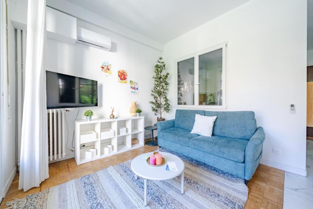 un salon avec un canapé bleu et une table dans l'établissement Charmant 2P au cœur de Nice, à Nice