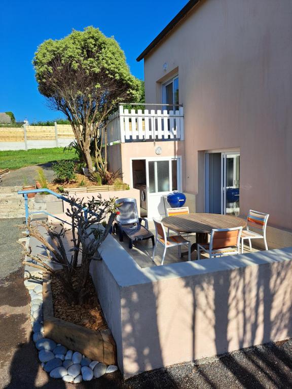 un patio avec une table et des chaises devant une maison dans l'établissement maison de vacances bord de mer, à Camaret-sur-Mer