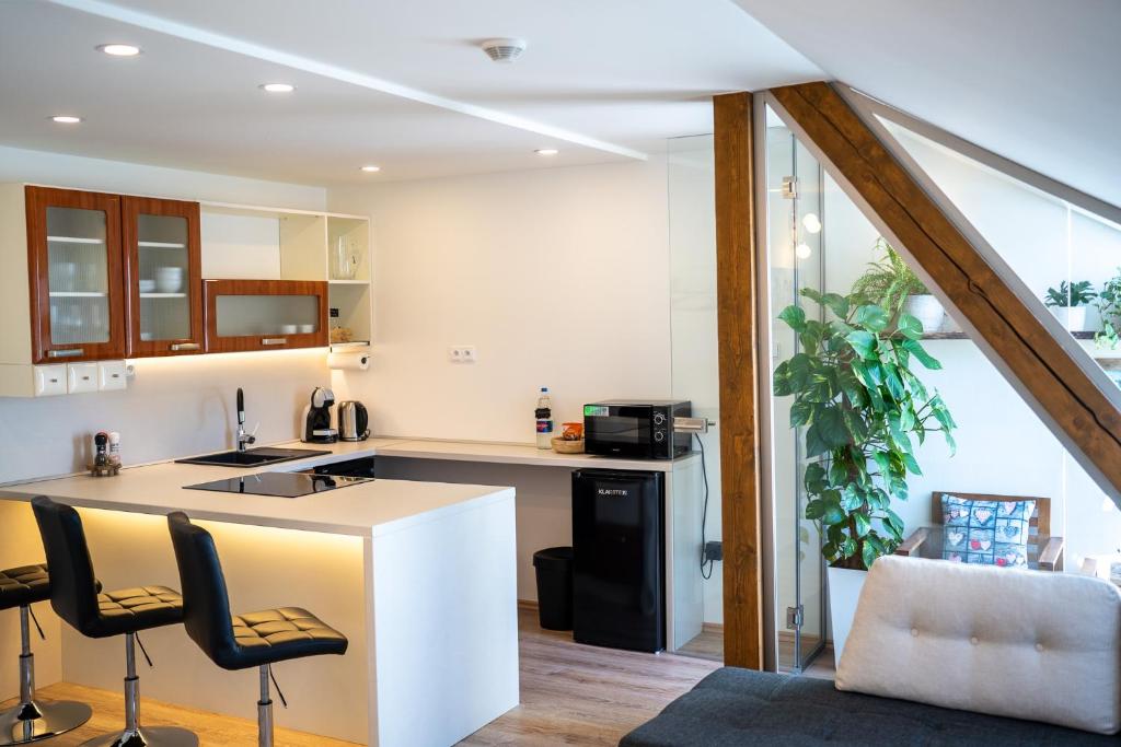 a kitchen with a counter and chairs in a room at Apartmány Revenite in Jeseník