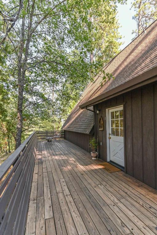 a house with a wooden deck with a white door at Hathaway Hideaway Loft Apartment in Hathaway Pines