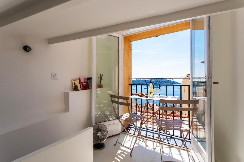 une chambre avec un balcon avec une table et des chaises dans l'établissement LA CASETTA DI AZZURRA AP4427 By Riviera Holiday Homes, à Villefranche-sur-Mer