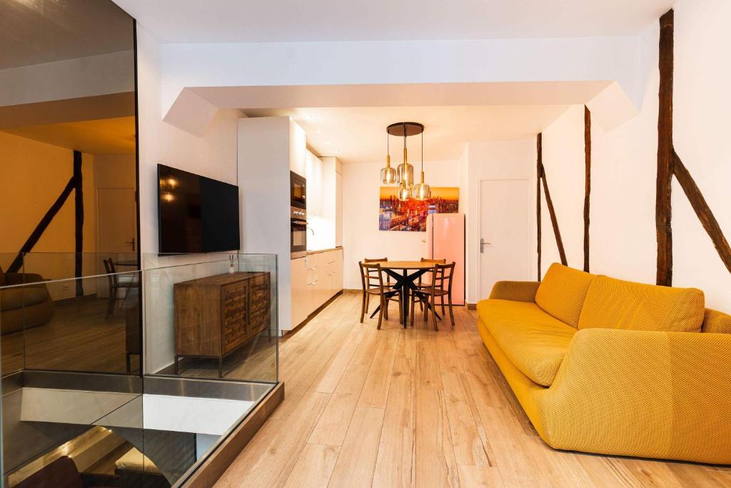 un salon avec un canapé jaune et une table dans l'établissement Loft 1 BR Marais, Notre Dame AC by LCC Agency, à Paris