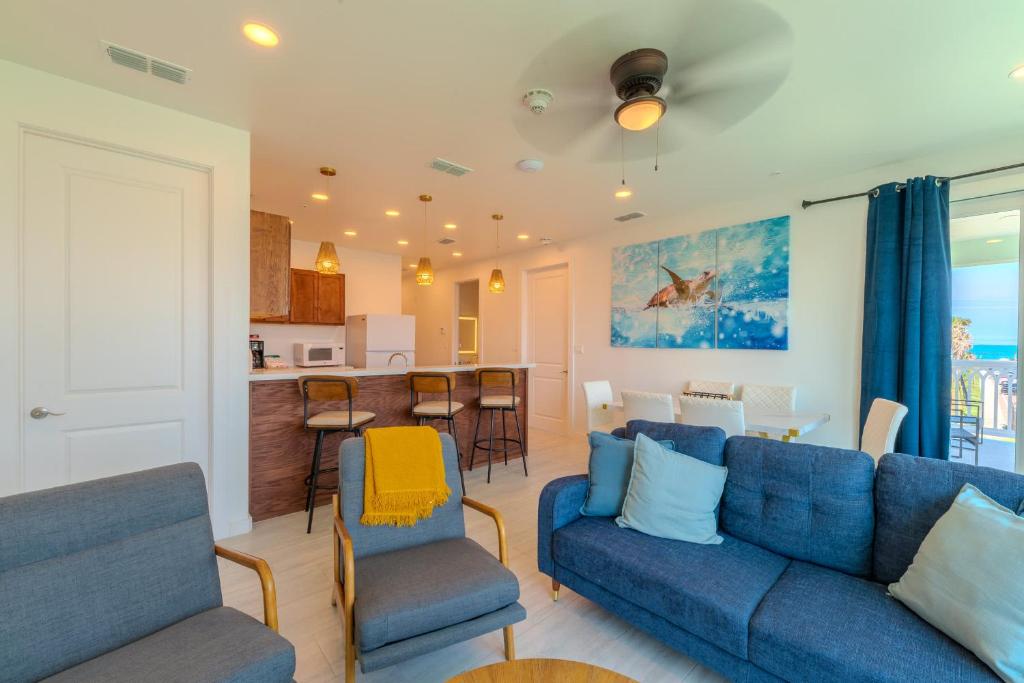 a living room with a blue couch and a kitchen at Marisol Condo 301 in South Padre Island