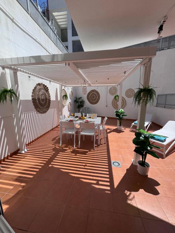 een patio met een tafel en stoelen in een gebouw bij Vamos Tenerife - Playa La Arena - Puerto De Santiago in Puerto de Santiago