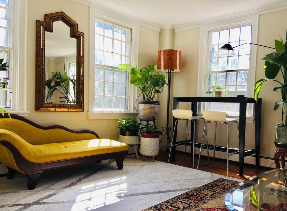 a living room with a yellow couch and a mirror at Downtown, Near RISD & Train, Walk Everywhere in Providence