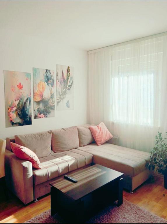 a living room with a couch and a coffee table at Alacaster G apartman FREE PARKING in Novi Sad