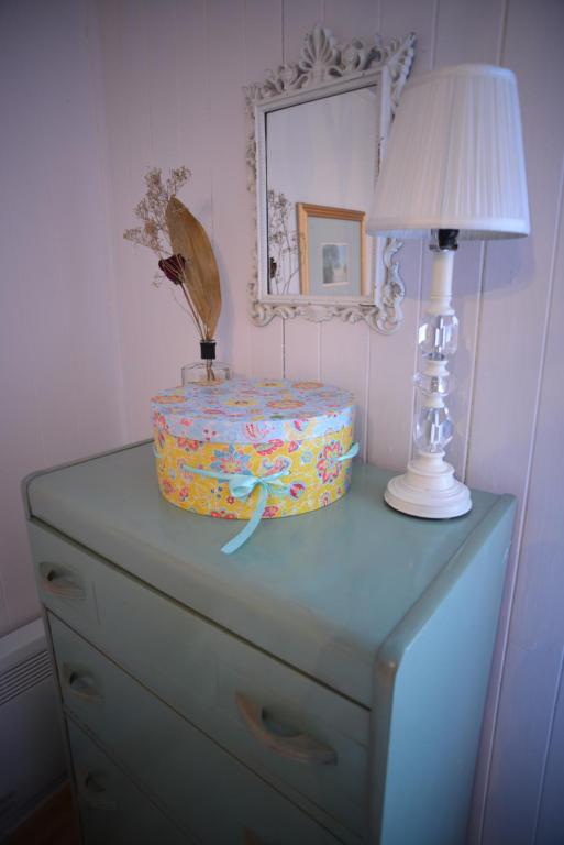 a dresser with a lamp and a cake on it at Auberge Évasion Nature Petite-Vallée in Petite-Vallée