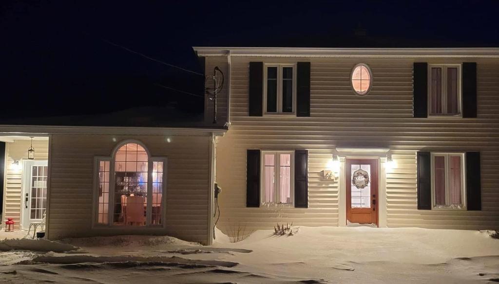 a house with a front door at night at Auberge Évasion Nature Petite-Vallée in Petite-Vallée