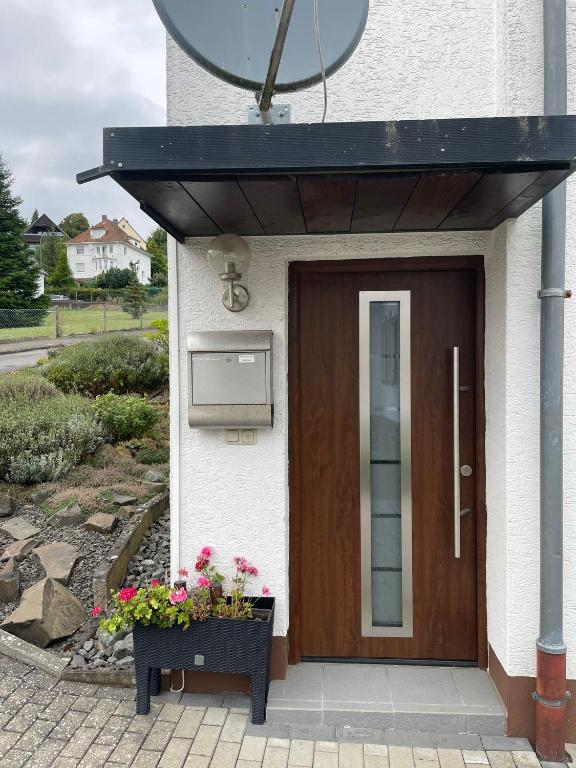 a house with a wooden door and flowers in front at Ferienwohnung im Ohmtal in Homberg an der Ohm