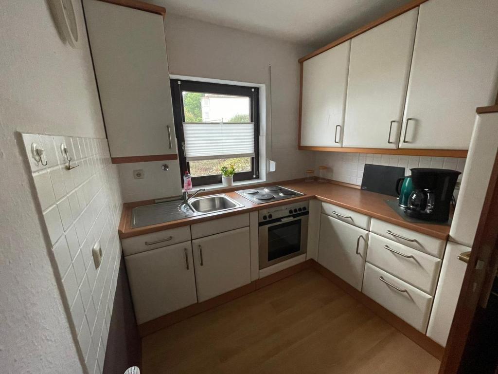 eine kleine Küche mit Spüle und Fenster in der Unterkunft Ferienwohnung im Ohmtal in Homberg Ohm