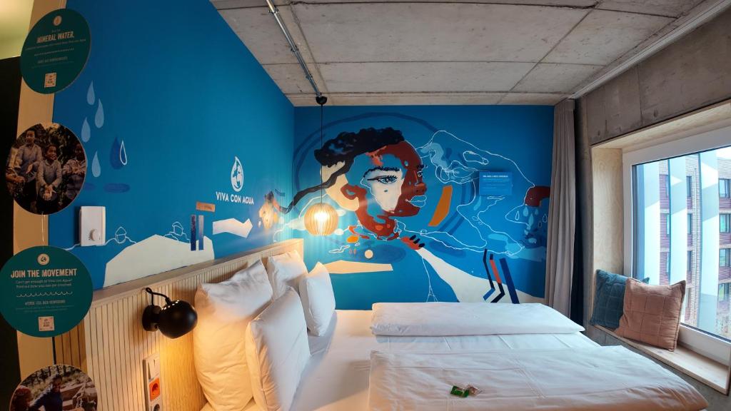 a bedroom with a blue wall with a mural at Villa Viva - ein Haus das Brunnen baut in Hamburg