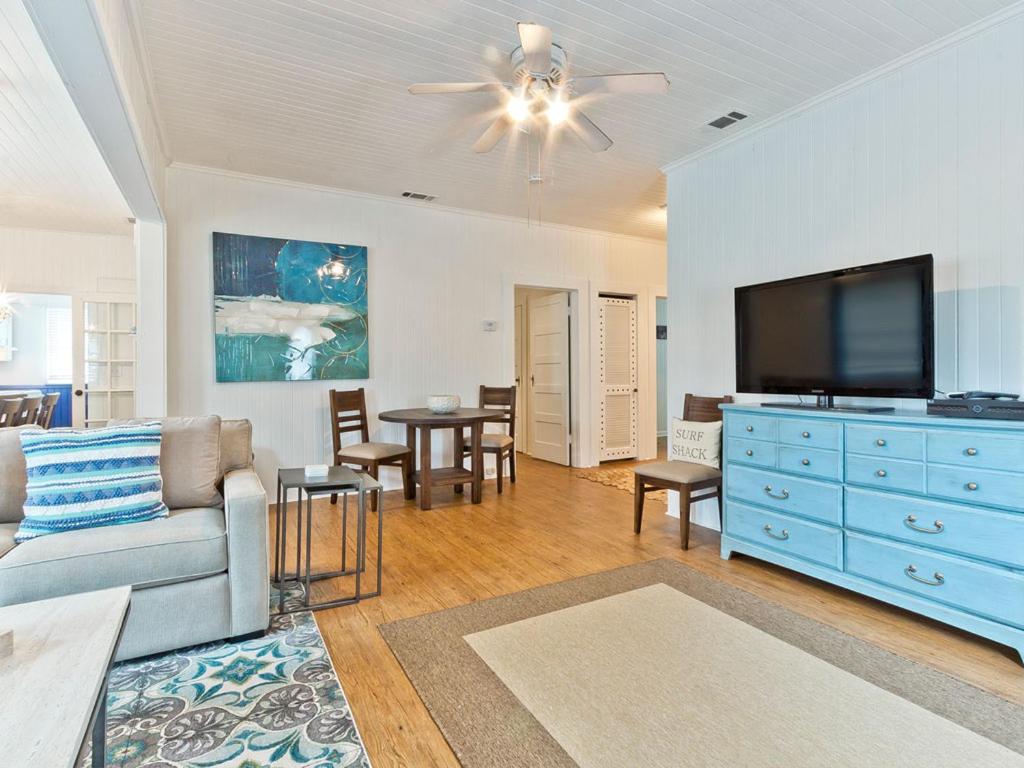 Una sala de estar con un sofá y un televisor de pantalla plana. en Bikini Top, en Tybee Island
