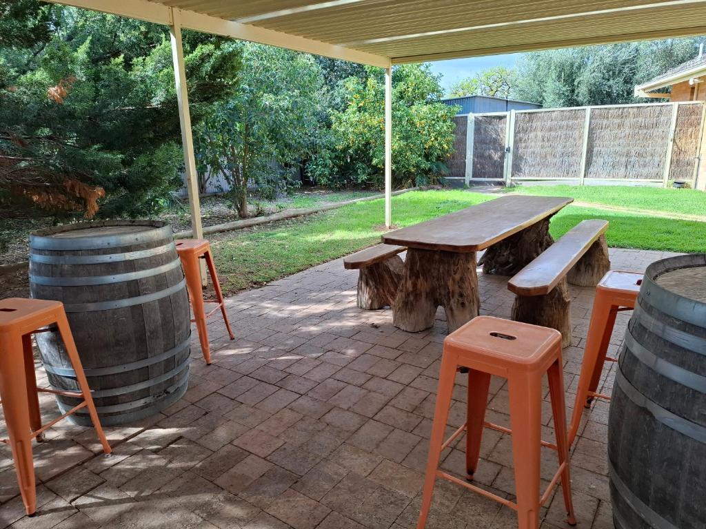 een picknicktafel en krukjes onder een paviljoen met vaten bij PAK House Central - New Listing! in Echuca