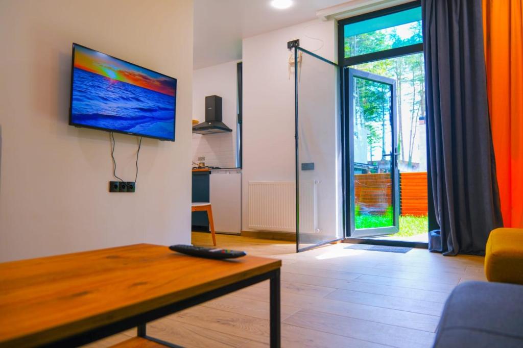 a living room with a table and a tv on a wall at Black Sea Gemini in Ureki
